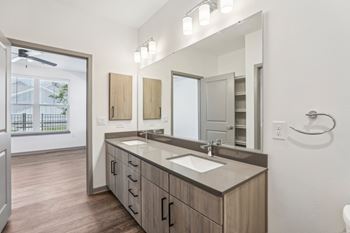A bathroom with a sink, mirror, and wooden cabinets.